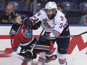 Oshawa Generals' Hunter Smith checks Kelowna Rockets' Cole Martin during round robin action at the Memorial Cup tournament. Smith, a Calgary Flames prospect, celebrated the title with his teammates on Sunday.