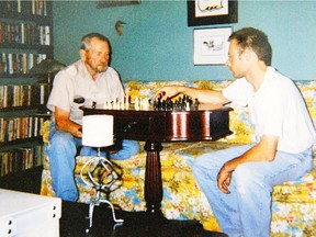Kevan Chandler, right, who was killed nine years ago in a High River grain silo, plays chess with his father.  More deaths will be prevented, now that the NDP has brought in legislation protecting  farm workers' labour and occupational health and safety rights.