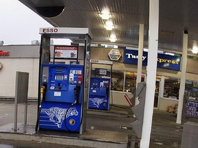 Flowers begin to appear at Esso Gas station where attendant Grant De Patie was working when he was killed by being draged  under a car by apparent gas theives. Pump number 8 (directly behind the flowers) is the reported spot of the event. (Steve Bosch/Vancouver Sun)