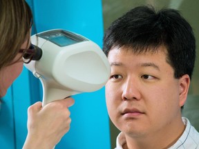 Jung-Suk Ryu has his eyes checked by optometrist Colleen Gnyp during a free eye exam at the Calgary Centre for Newcomers on Monday May 12, 2014. The CNIB spokesman says the Alberta government should fund more programs for the blind and visually impaired.