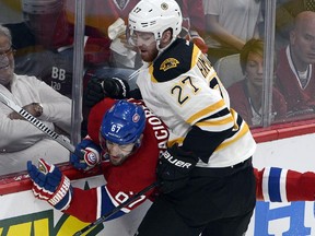Montreal Canadiens' Max Pacioretty (67) is checked into the boards by Boston Bruins' Dougie Hamilton (27) during first period NHL Stanley Cup playoff action Monday, May 12, 2014 in Montreal.