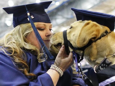 Mount Royal University disability studies graduate Alyssa Denis shares a moment with her service dog Moxie before graduating and delivering the valedictorian speech on Thursday June 4, 2015. Denis credits Moxie and a previous service dog Luna for helping her deal with the debilitating effects of Lupis and getting her life back on track.