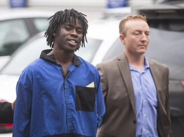 Lloyd Kollie, 19, accused in the murder of Maqsood Ahmed is brought to the Calgary Police processing unit in Calgary on Wednesday, June 17, 2015.