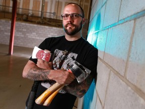 Matt Wilson of BATL Alternative Sports holds some of the axes that are used in the sport of axe throwing in a warehouse that will be soon be the first axe throwing venue in Western Canada.