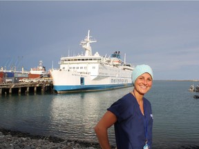 Operating room nurse Tara McHardy poses in front of the boat the volunteers aboard, the Africa Mercy. Photo from mercyships.ca