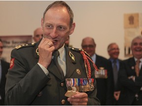 Lt.-Gen. Mart de Kruif, Commander of the Royal Netherlands Army, tests out a 70-year-old biscuit at the Military Museums in Calgary, on June 20, 2015, as he helps open a humanitarian aid box, that was dropped in the Netherlands from the Canadians during the Second World War.