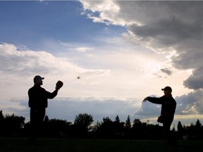 Lance Clark plays catch with his son Geoff just after a rainstorm on June 7, 2001.