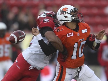 B.C. Lion quarterback Jonathon Jennings, right, is sacked by Calgary Stampeder linebacker Deron Mayo at McMahon Stadium in Calgary on Friday, June 12, 2015. The Calgary Stampeders tied the B.C. Lions, 6-6, at the end of the half in an pre-season exhibition game.