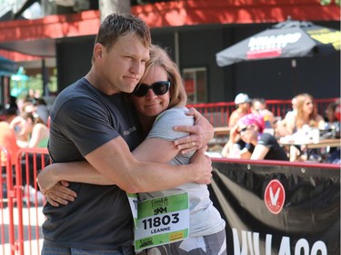 Heath McCoy, husband of Tamara Gignac a Herald reporter who died of Cancer on Friday, gets a hug from Leanne Dohy as friends and family prepared to walk/run in her honour at the 5 km portion of the Scotiabank Marathon.