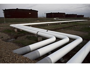 Pipelines run toward oil storage tanks stand at the Enbridge Inc. Cushing storage terminal in Cushing, Oklahoma, U.S., on Wednesday, March 25, 2015.
