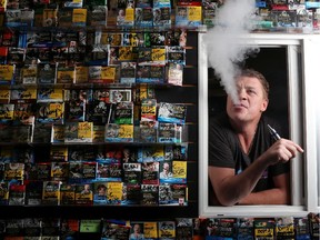 Travis Gerlitz smokes an e-cigarette at his shop Global Haze Electric Cigarette.