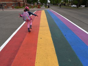 Six-year-old Kenzy Francis crosses a rainbow coloured crosswalk in Old Strathcona in Edmonton on Tuesday, June 2.