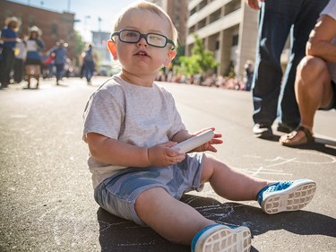 Jackson draws on the street across from the Bow with chalk prior to the start Calgary Stampede Parade in Calgary on Friday, July 3, 2015.