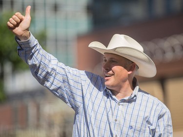 Greg Clark gives a thumbs up at the Calgary Stampede Parade in Calgary on Friday, July 3.