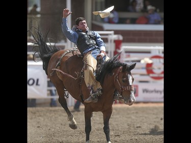 Tanner Aus looses his hat during the bareback event at the Calgary Stampede Rodeo at the Stampede Grandstand in Calgary on Saturday, July 4, 2015.