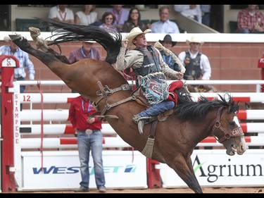 Cody Wright is tossed about during the saddle bronc event at the Calgary Stampede Rodeo at the Stampede Grandstand in Calgary on Saturday, July 4, 2015.