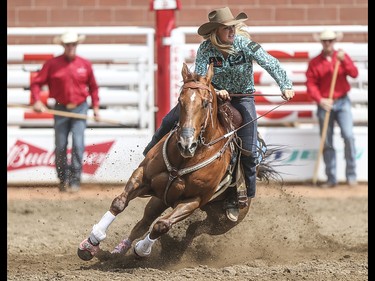Sydney Daines takes the third barrel during the barrel riding event at the Calgary Stampede Rodeo at the Stampede Grandstand in Calgary on Saturday, July 4, 2015.