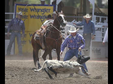 Ryan Jarret yanks his calf to the ground at the tie-down roping event at the Calgary Stampede Rodeo at the Stampede Grandstand in Calgary on Saturday, July 4, 2015.