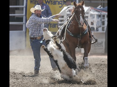 Lee Rombough jumps off his horse to chase his calf at the tie-down roping event at the Calgary Stampede Rodeo at the Stampede Grandstand in Calgary on Saturday, July 4, 2015.