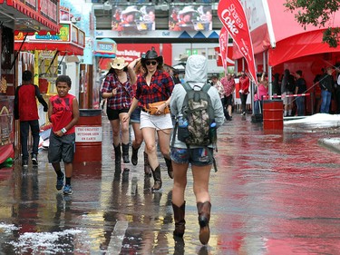 Ann Reaney runs through a puddle as she was getting out of the storm that left the Stampede Grounds looking like it had snowed on Saturday.