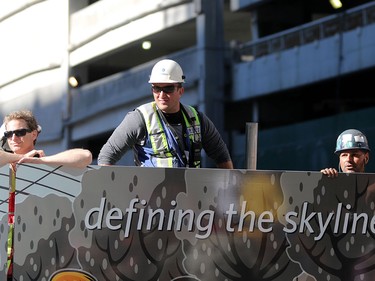 Construction workers line the parade route to take in the Calgary Stampede parade on July 3.