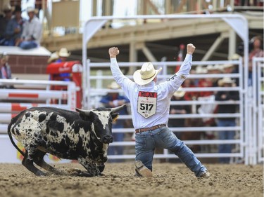 Tanner Milan cheers after he wrestles his way to a first place finish during day three steer wrestling action at the 2015 Calgary Stampede, on July 5, 2015.