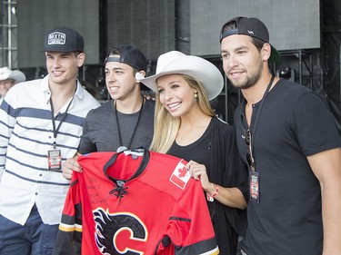 Miss America, Kira Kazantsev, is presented a with Calgary Flames jersey by players Josh Jooris, Sean Monahan, and Johnny Gaudreau in front of a crowd of thousands at the Calgary Stampede Roundup at Fort Calgary in Calgary on Wednesday, July 8, 2015.
