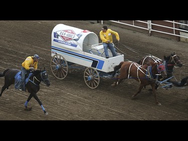 Doug Irvine, right, looks back to see how far ahead he is in heat two, day nine, of the GMC GMC Rangeland Derby at the Calgary Stampede Grandstand in Calgary on Saturday, July 11, 2015.