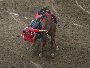 Outrider Quaid Tournier is tossed from his horse in heat four, day nine, of the GMC GMC Rangeland Derby at the Calgary Stampede Grandstand in Calgary on Saturday, July 11, 2015.