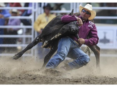 Dru Melvin wrestles his steer down in time for a fourth place finish during Day 9 of steer wrestling rodeo action at the 2015 Calgary Stampede, on July 11, 2015.