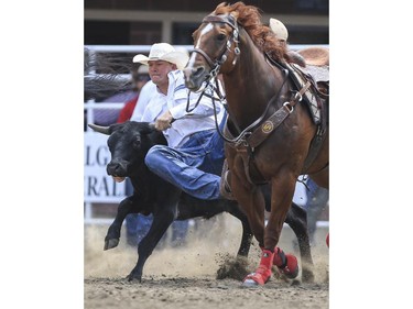 Ty Erickson takes down his steer in time for a second place finish during Day 9 of steer wrestling rodeo action at the 2015 Calgary Stampede,, on July 11, 2015.