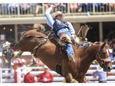 Tanner Aus holds on to Risque Elsie for a eighth place finish during Day 9 of bareback rodeo action at the 2015 Calgary Stampede,, on July 11, 2015.