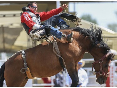 Dusty LaValley shows Knight Rocket who's boss for a first place ride during Day 9 of bareback rodeo action at the 2015 Calgary Stampede,, on July 11, 2015.