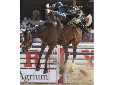 Jake Vold holds on tight to Waskasoo Soot for a fourth place finish during Day 9 of bareback rodeo action at the 2015 Calgary Stampede,, on July 11, 2015.