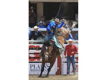 Lane Cust rides Nitro Mountain during day 9 of novice saddle bronc action at the 2015 Calgary Stampede, on July 11, 2015.