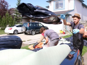 Volunteers with Christian Disaster Relief made their way around Chestermere helping to clear away damaged materials  on July 15, 2015 following the storm waters which flooded many homes. Many homes in the community east of Calgary were damaged when a large storm dumped around 200 mm of rain on Sunday, followed by another storm on Tuesday.