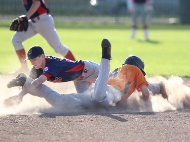 Calgary AAA Giants runner Connor Veillet, in orange, slid back into second base while Calgary AAA Indians Steven Wanvig reached for the ball during game 2 of the best of three Babe Ruth league finals on July 30, 2015.