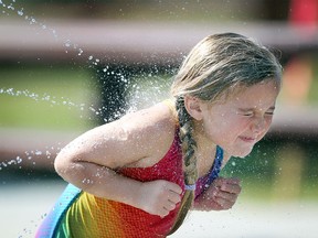 Calgary's Camryn Hewitt, 4, beat the heat by playing in the cool spray at the newly reopened South Glenmore Park Spray Park with her family on July 31, 2015. Temperatures were expected to reach 30C and stay warm through the weekend.