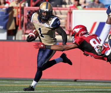 Calgary Stampeders Eric Rogers, right,  tackles Winnipeg Blue Bombers Troy Stoudermire during their game at McMahon Stadium on July 18, 2015.