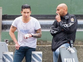 Man with the bandaged hand is Jeffery Chang, who was connected to the Wolf Pack gang. Here, police probe the crime scene after shots were fired at East Hastings and Vernon streets in Vancouver on June 8, 2014. Chang has since died after being found unconscious.