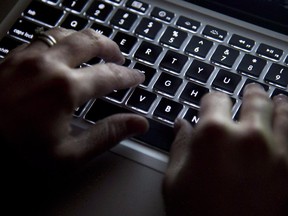 A woman uses her computer keyboard to type while surfing the internet in North Vancouver, B.C., on Wednesday, December, 19, 2012. Digital dissenters known as hacktivists have developed a track record for disruption and attracting attention and are now considered one of the three main groups of attackers online, says security software company Websense. THE CANADIAN PRESS/Jonathan Hayward ORG XMIT: CPT501