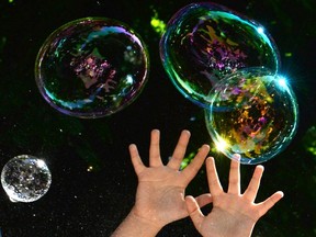 A child plays with soap bubbles during a charity event for children with autism.