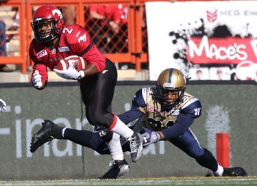 Calgary Stampeders Tim Brown, left, evades Winnipeg Blue Bombers Brendan Morgan during their game at McMahon Stadium on July 18, 2015.