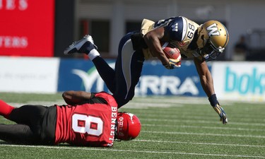 Calgary Stampeders Fred Bennett tackles Winnipeg Blue Bombers Clarence Denmark during their game at McMahon Stadium on July 18, 2015.