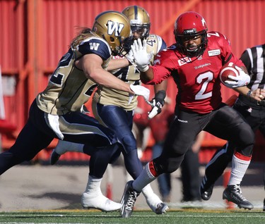 Calgary Stampeders Tim Brown, right, tries to evade Winnipeg Blue Bombers Garrett Waggoner during their game at McMahon Stadium on July 18, 2015.