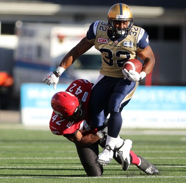 Calgary Stampeders Deron Mayo, left, tackles Winnipeg Blue Bombers Cameron Marshall during their game at McMahon Stadium on July 18, 2015.