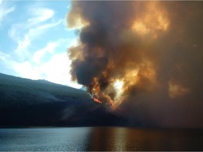 A wildfire rises over a hill in Jasper National Park on Thursday July 9, 2015. An evacuation of part of Jasper National Park has been ordered due to a forest fire in the picturesque Maligne Valley.