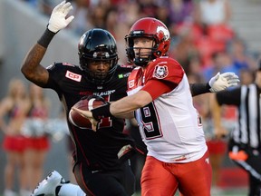 Ottawa Redblacks' Aston Whiteside moves in to knock the ball from the hand of Calgary Stampeders' Bo Levi Mitchell during second quarter CFL football action in Ottawa on Friday, July 24, 2015. Whiteside gained possession of the ball to make an interception.