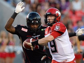 Ottawa Redblacks' Aston Whiteside moves in to knock the ball from the hand of Calgary Stampeders' quarterback Bo Levi Mitchell during Ottawa's overtime victory on Friday.