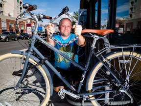 Sean Carter, owner of Bike Bike YYC, holds up a folding lock at his shop in Calgary on Wednesday, July 29, 2015. Carter recommends the folding lock to prevent thefts as it contains features that make cutting or tearing the lock difficult.